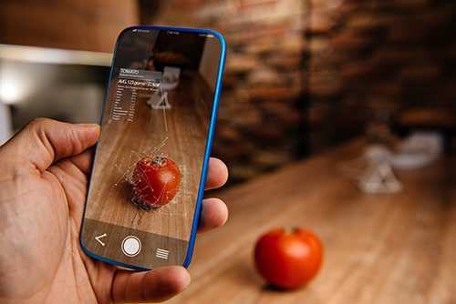 Woman holding smartphone visualizing an apple with AI