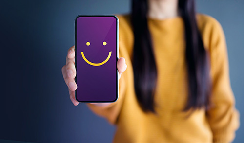 Woman holding a Smartphone with a smiley face